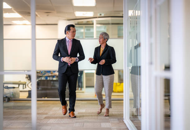Two colleagues in conversation in an office corridor